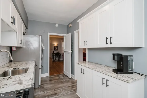 a kitchen with granite countertop a sink a stove and refrigerator