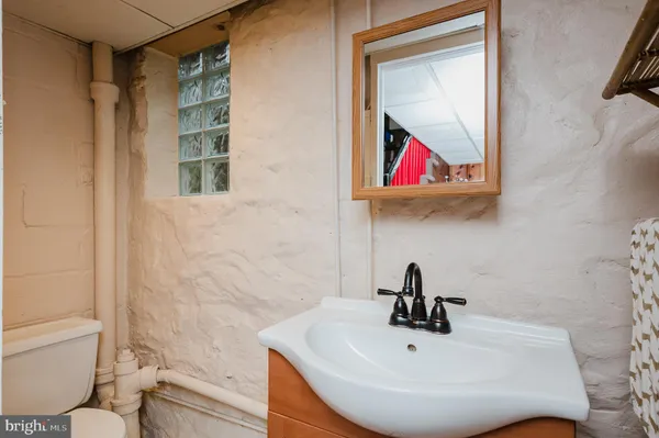 a bathroom with a sink a toilet and a mirror