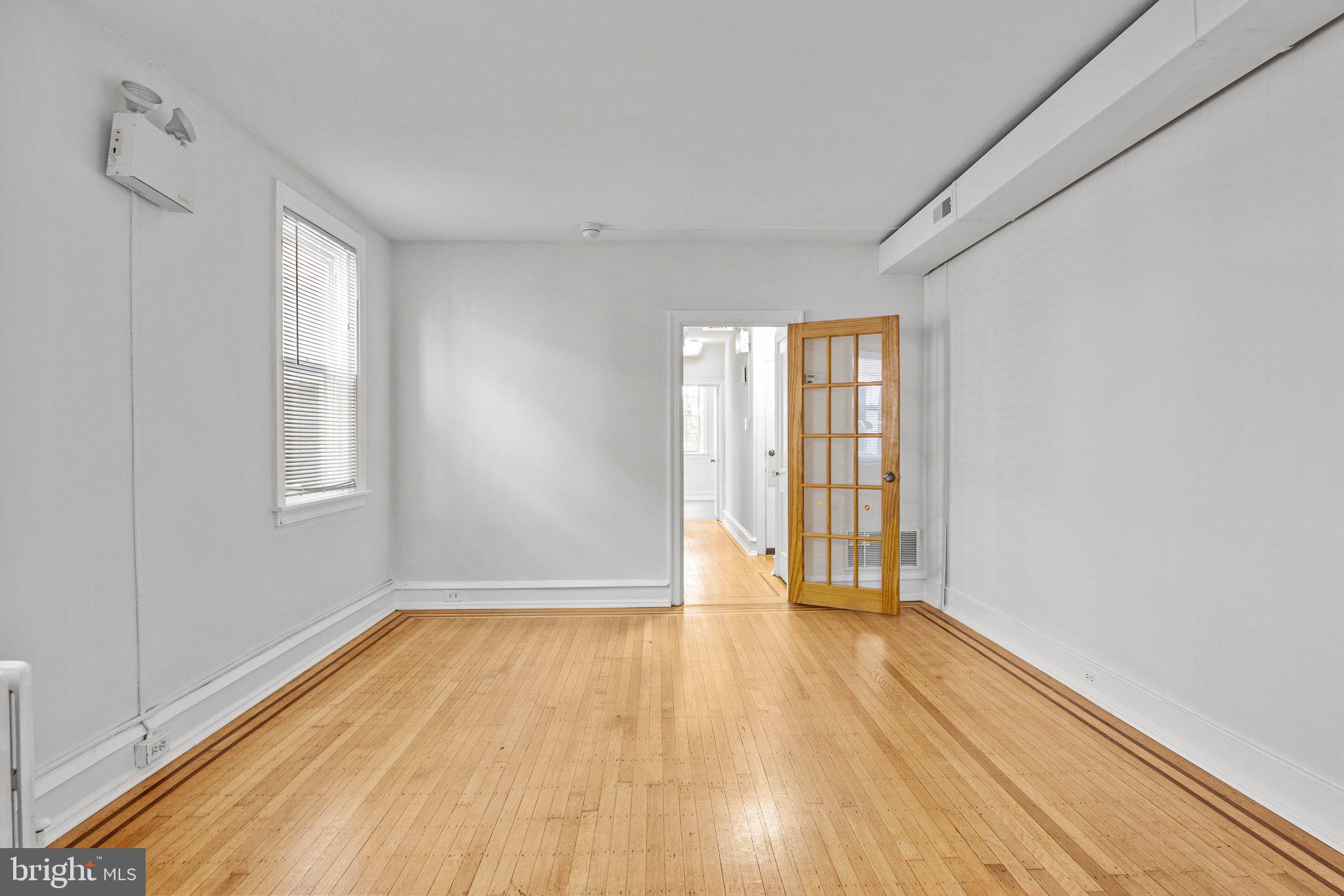87 East Butler Avenue Ambler, PA 19002 - Photo 7 of 17 a view of an empty room with wooden floor and a window