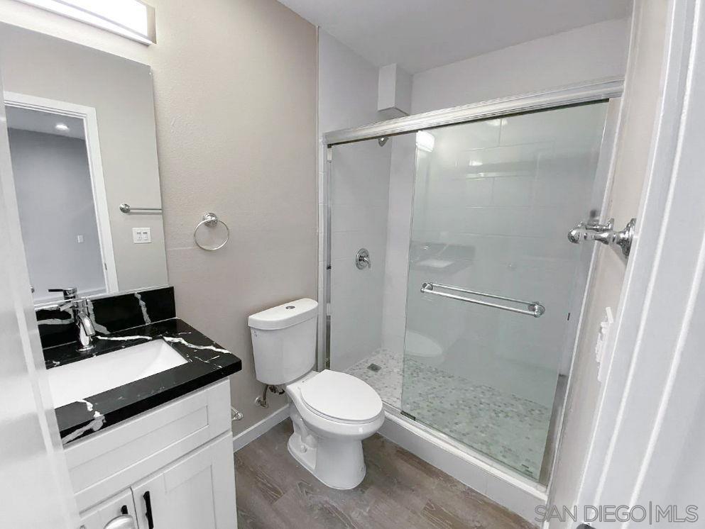 6497 Montezuma Road San Diego, CA 92115 - Photo 13 of 23 a bathroom with a toilet a sink and a shower