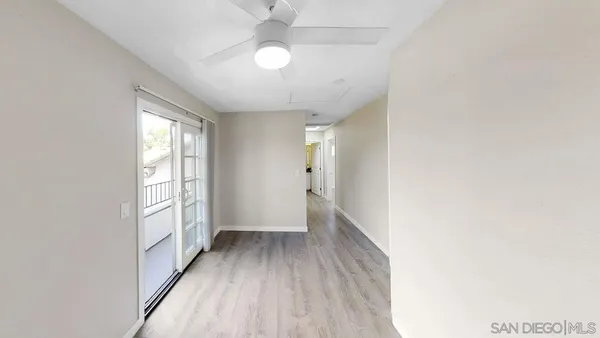 a view of an empty room with window and closet area