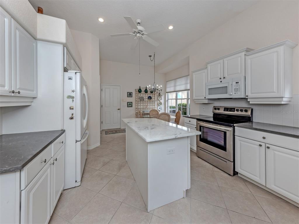 338 St George Court, Unit 11 Venice, FL 34293 - Photo 15 of 79 a kitchen that has a lot of white cabinets and stainless steel appliances