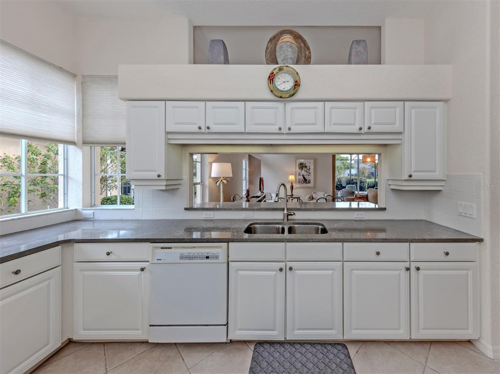 338 St George Court, Unit 11 Venice, FL 34293 - Photo 16 of 79 a kitchen with white cabinets and clock