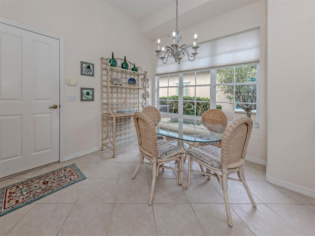 338 St George Court, Unit 11 Venice, FL 34293 - Photo 19 of 79 a dining room with furniture a rug and a chandelier
