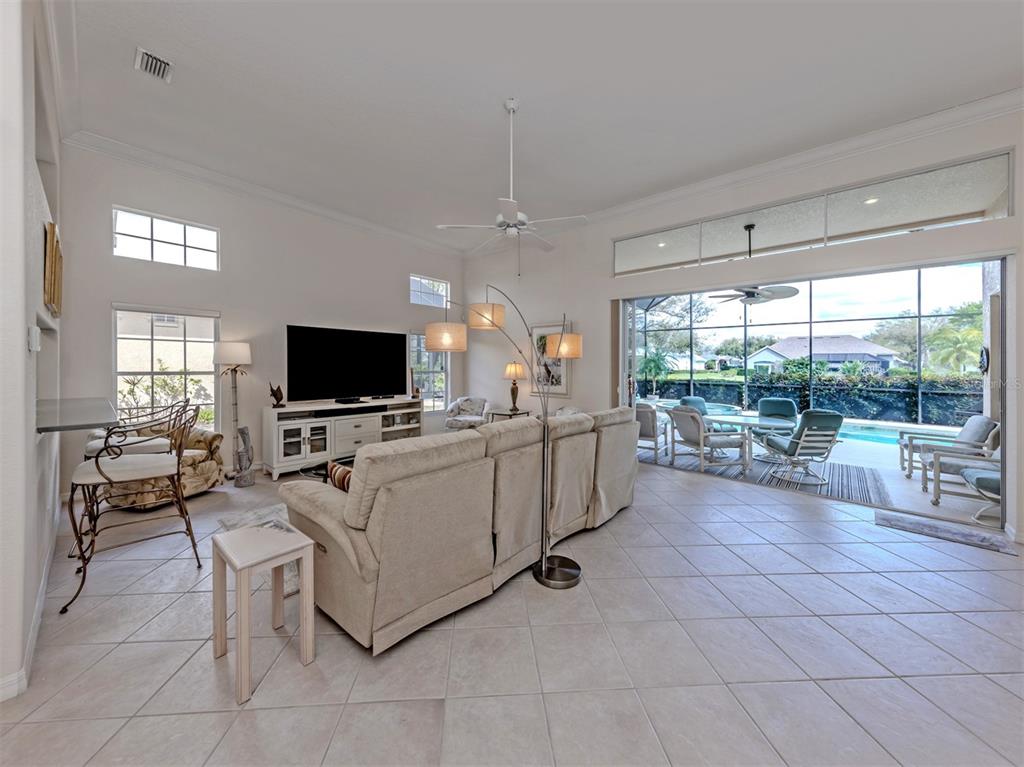 338 St George Court, Unit 11 Venice, FL 34293 - Photo 7 of 79 a living room with furniture and a flat screen tv
