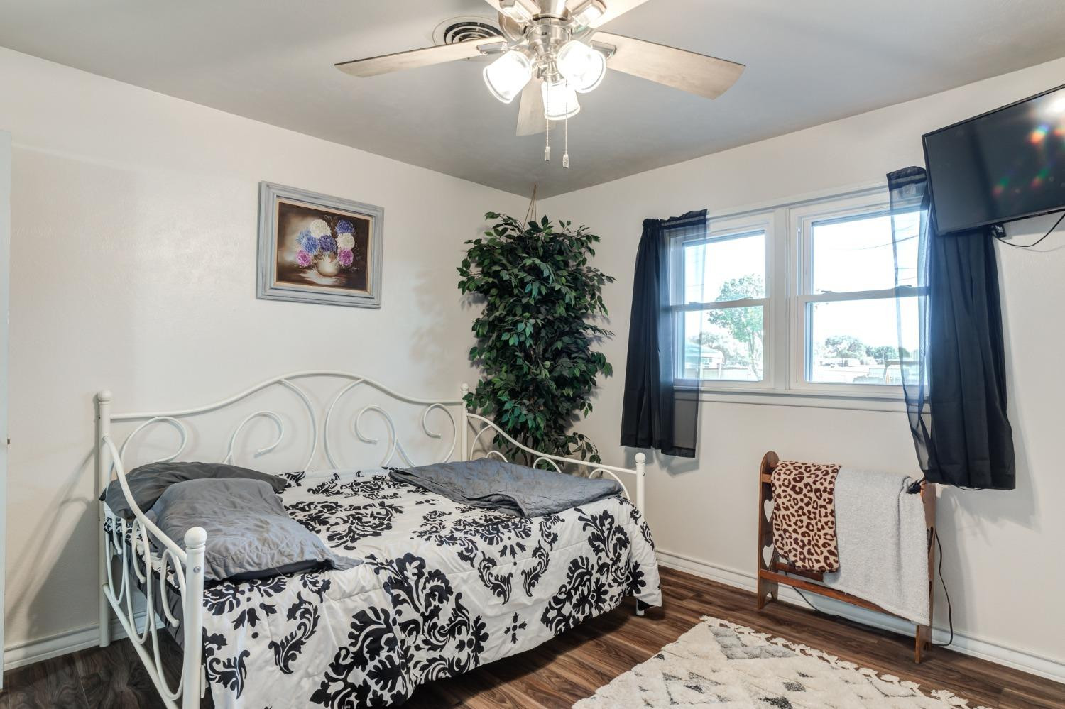 334 West Ave J Muleshoe, TX 79347 - Photo 11 of 18 a bedroom with a bed and a chandelier