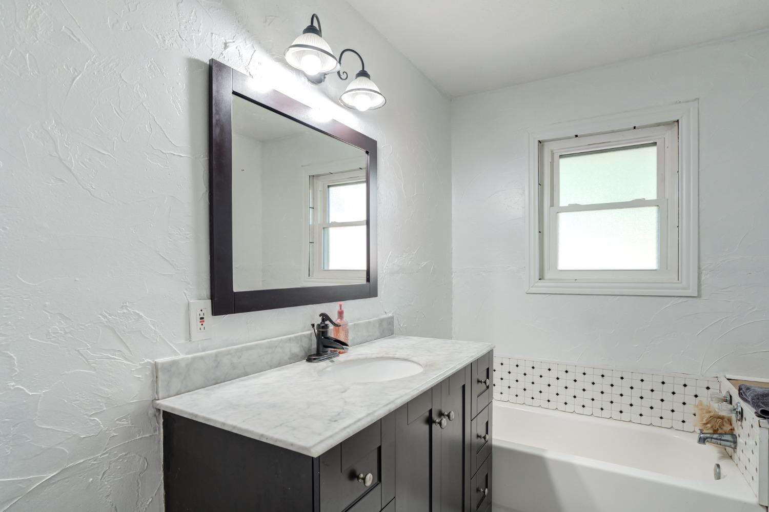334 West Ave J Muleshoe, TX 79347 - Photo 12 of 18 a bathroom with a sink vanity and a mirror