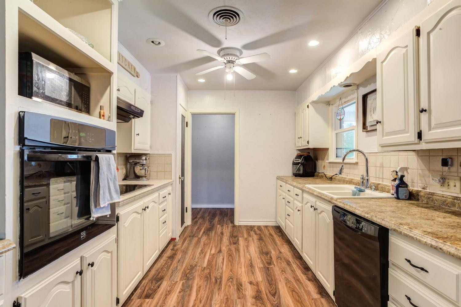 334 West Ave J Muleshoe, TX 79347 - Photo 5 of 18 a kitchen with stainless steel appliances granite countertop a sink and cabinets