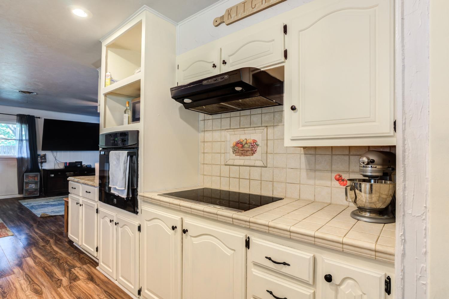 334 West Ave J Muleshoe, TX 79347 - Photo 6 of 18 a kitchen with stainless steel appliances a stove a microwave and white cabinets
