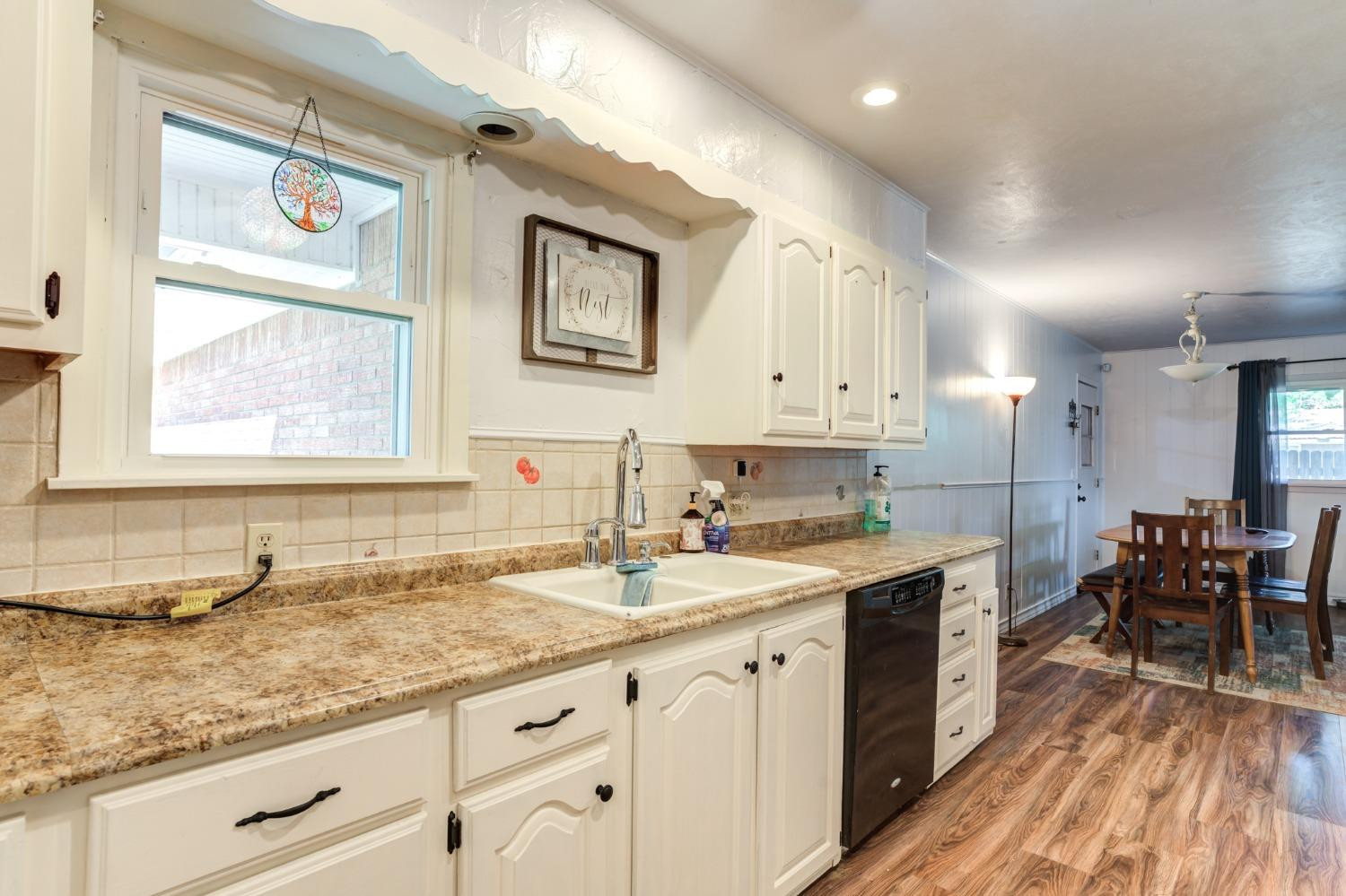 334 West Ave J Muleshoe, TX 79347 - Photo 7 of 18 a kitchen with granite countertop a sink stainless steel appliances white cabinets and wooden floor
