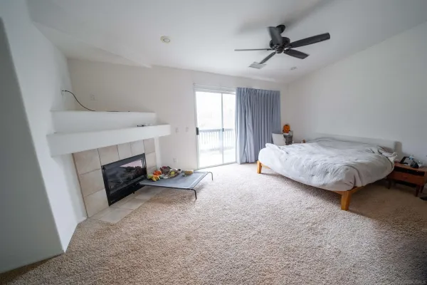 a spacious bedroom with a bed a fireplace and a chandelier