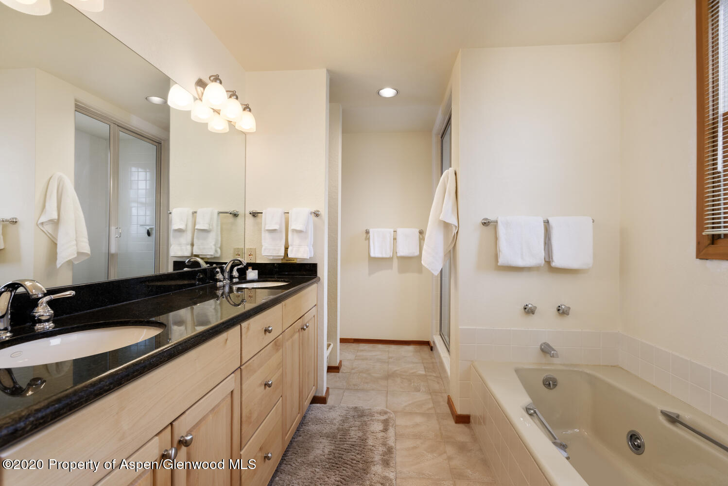 425 Wood Road, Unit 6 Snowmass Village, CO 81615 - Photo 12 of 16 a spacious bathroom with a granite countertop sink mirror and a bathtub