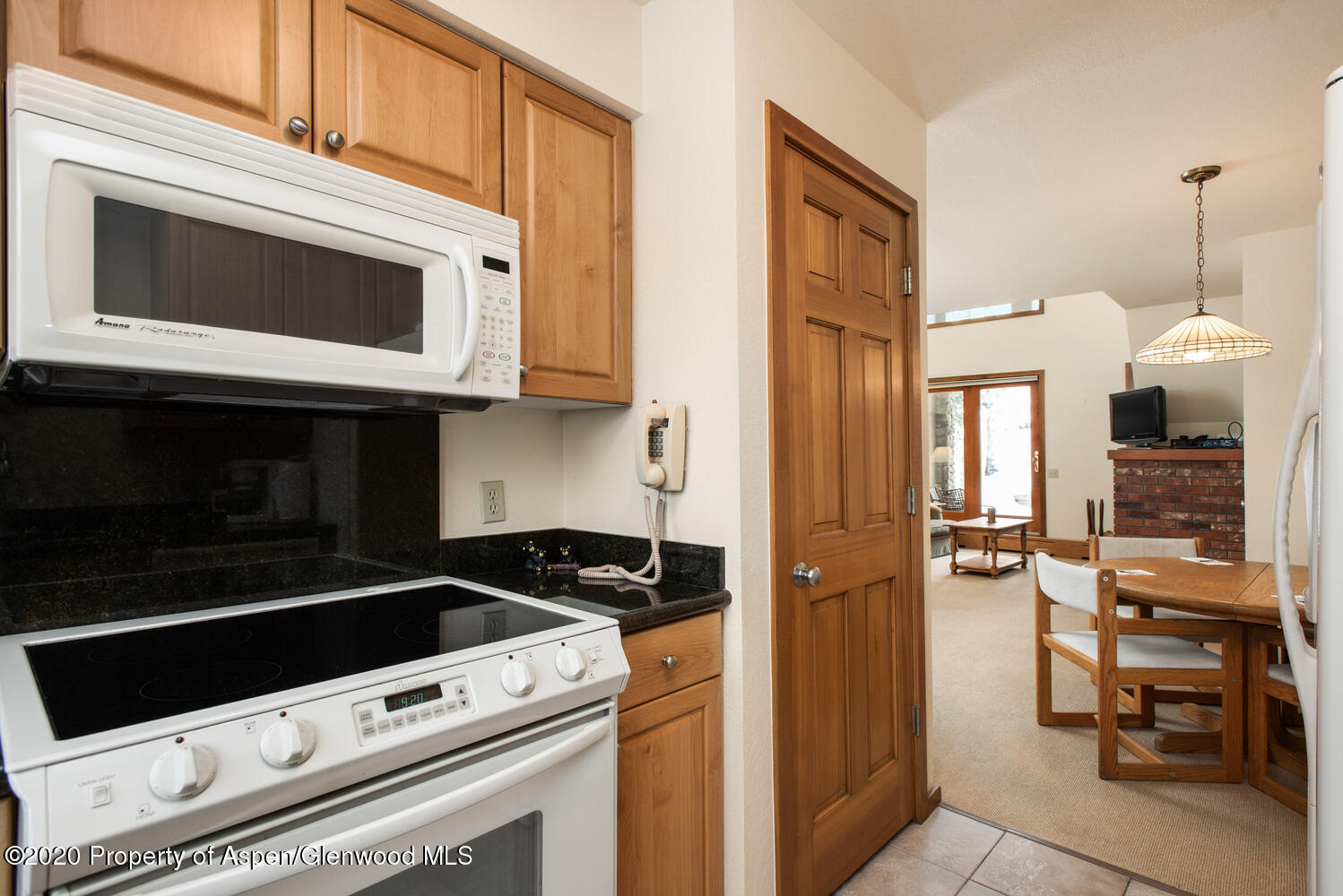 425 Wood Road, Unit 6 Snowmass Village, CO 81615 - Photo 10 of 16 a kitchen with granite countertop cabinets stainless steel appliances and wooden floor