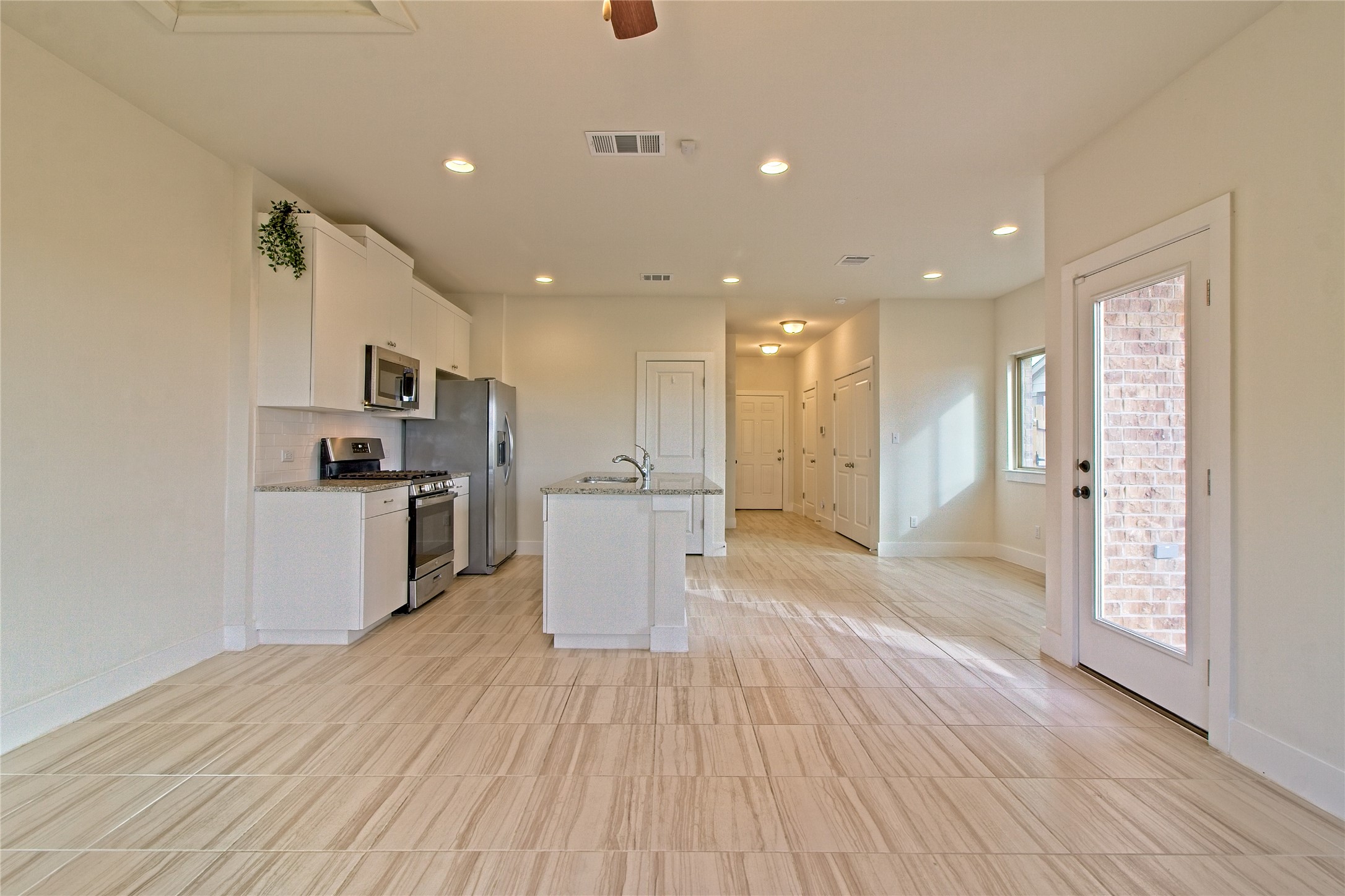 555 White Steppe Way Georgetown, TX 78626 - Photo 16 of 40 a view of kitchen with stainless steel appliances kitchen island wooden floors and granite counter tops