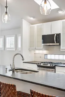 a kitchen with stainless steel appliances granite countertop a sink a stove and a microwave