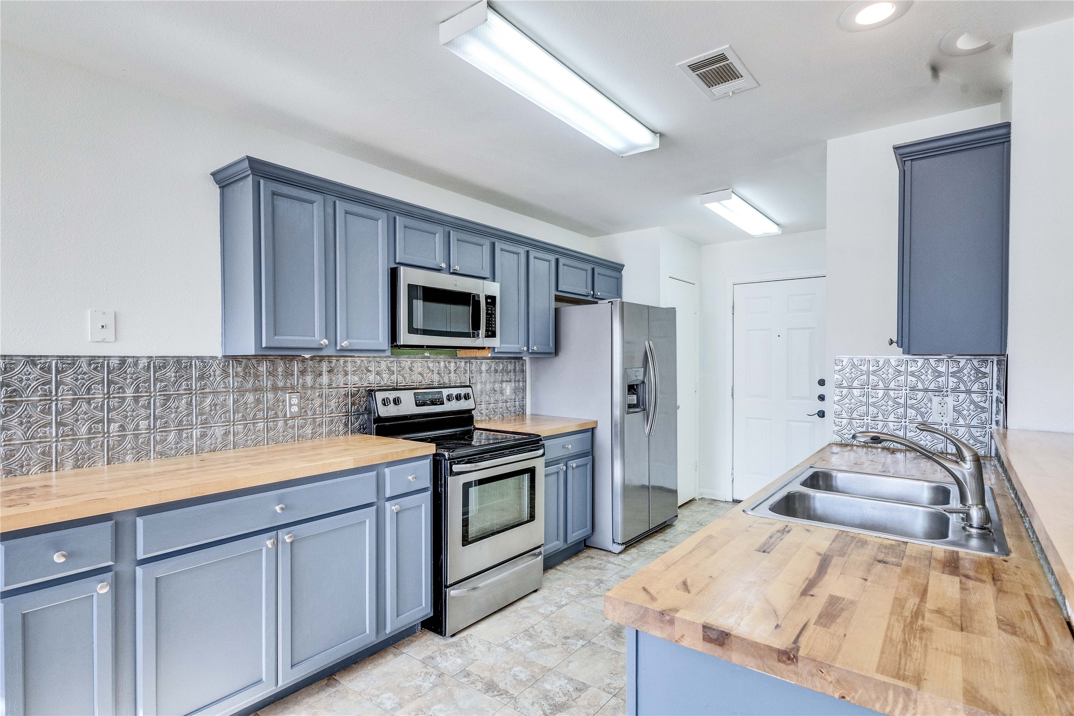 1103 Madison Temple, TX 76504 - Photo 3 of 26 Kitchen with stainless steel appliances, butcher block counters, backsplash, and blue cabinets