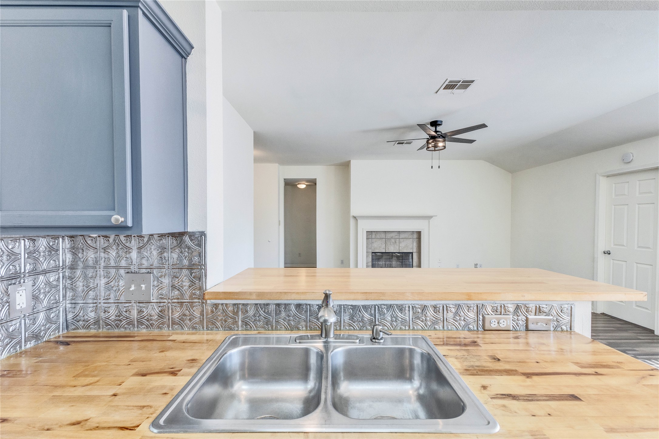 1103 Madison Temple, TX 76504 - Photo 26 of 26 Kitchen featuring wood counters, a tile fireplace, ceiling fan, open floor plan, and lofted ceiling