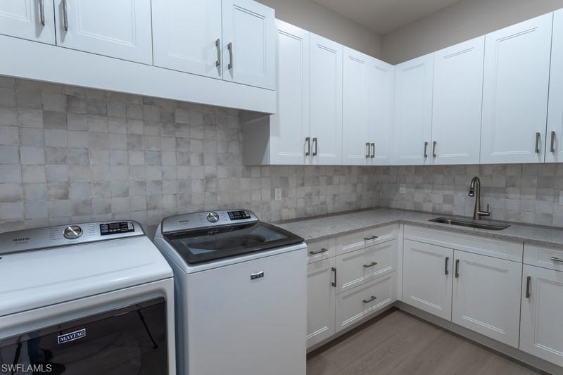 9587 Caymas Way Naples, FL 34114 - Photo 6 of 7 a close view of a sink a stove and cabinets