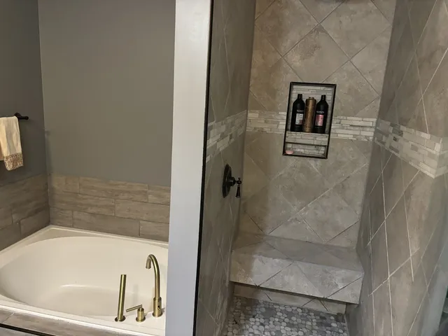 a bath tub sitting next to a white toilet and sink