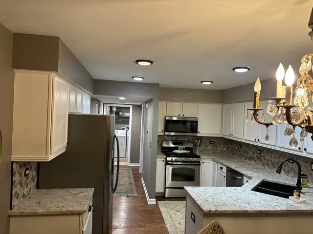 a kitchen with stainless steel appliances granite countertop a refrigerator a sink and a stove