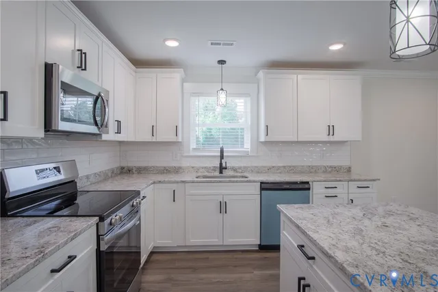 a kitchen with kitchen island a sink stainless steel appliances and cabinets