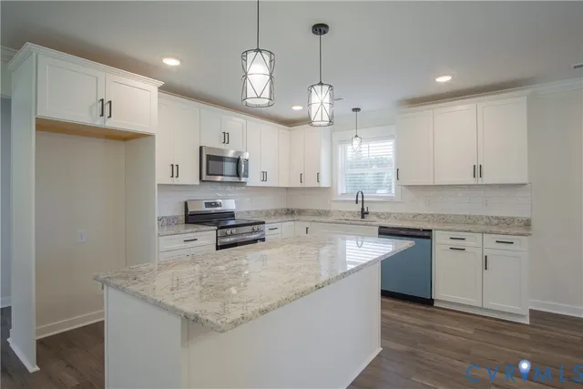 a kitchen with stainless steel appliances granite countertop a sink a stove and a wooden floors