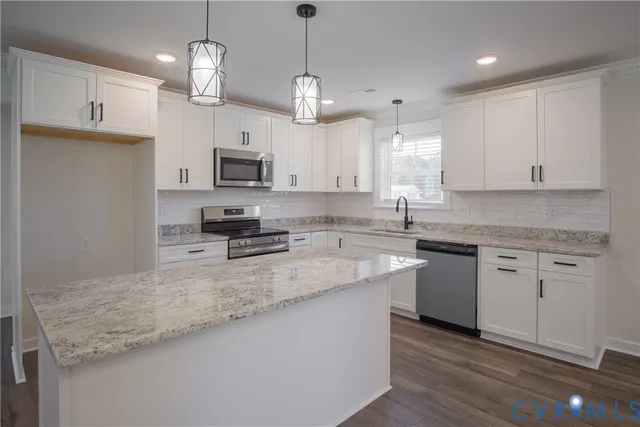 an empty room with wooden floor cabinet and windows