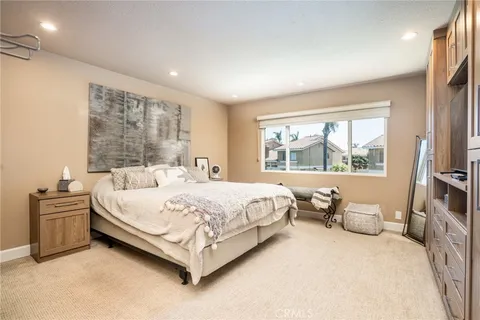 a large bed sitting in a bedroom next to a window