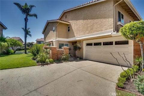 a front view of a house with a yard and potted plants