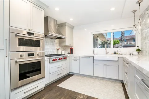 a kitchen with white cabinets appliances and a sink