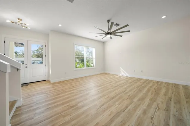 a view of a livingroom with wooden floor and a ceiling fan
