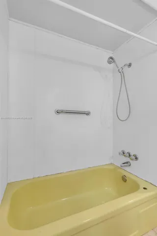 a bathroom with a bath tub with a shower