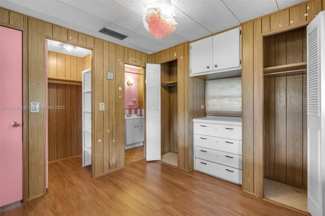 a view of walk in closet with wooden floor