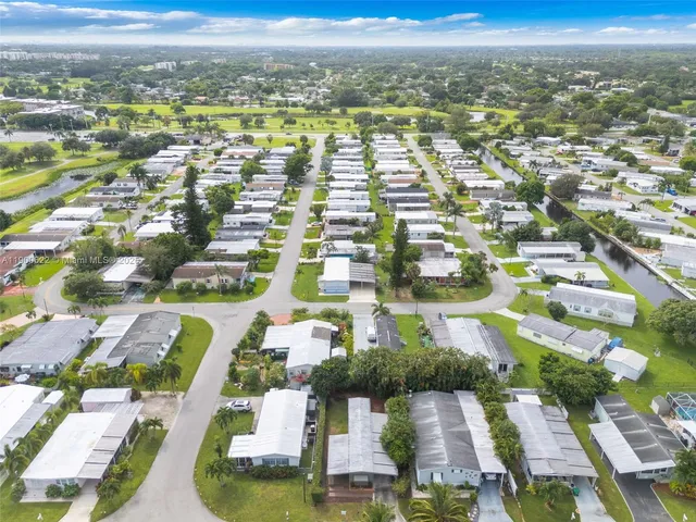 an aerial view of residential houses with outdoor space and ocean view