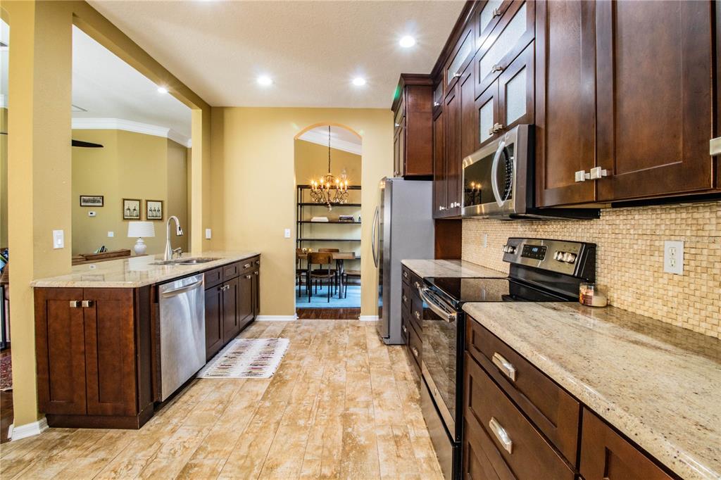 3234 Stonebridge Trail Valrico, FL 33596 - Photo 14 of 34 a large kitchen with stainless steel appliances granite countertop a stove a sink and a refrigerator