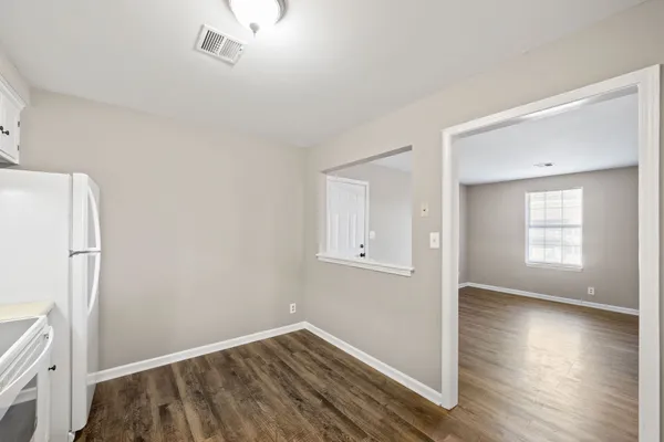 a view of a room with wooden floor and a window