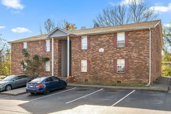 a car parked in front of a brick house