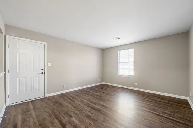 a view of room with window and wooden floor