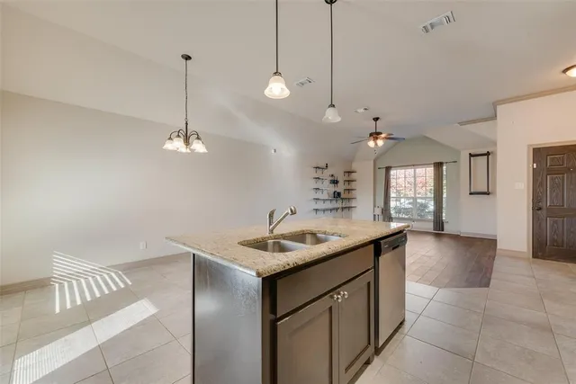 a kitchen with a sink a counter space and a chandelier