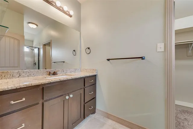 a bathroom with a granite countertop sink and a mirror