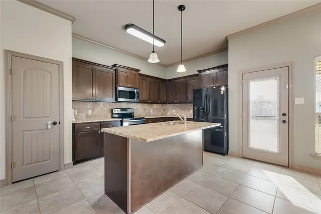 a large kitchen with cabinets and stainless steel appliances