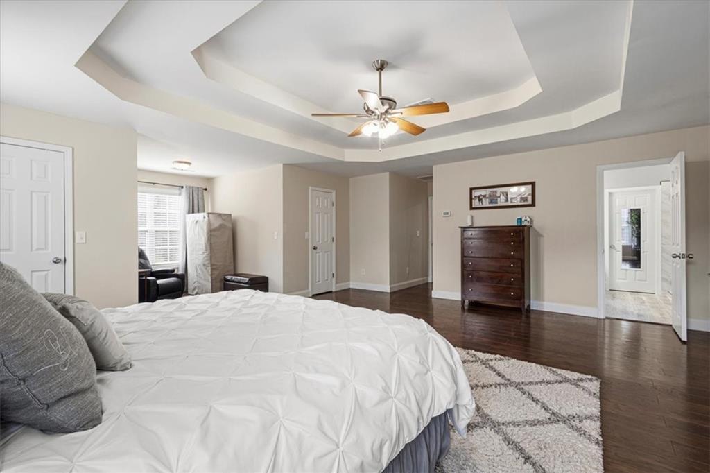 1380 Commonwealth Lane Grayson, GA 30017 - Photo 28 of 46 a spacious bedroom with a bed and a chandelier