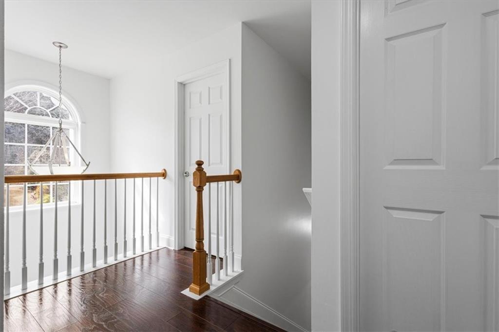 1380 Commonwealth Lane Grayson, GA 30017 - Photo 32 of 46 a view of a hallway with wooden floor and a chandelier