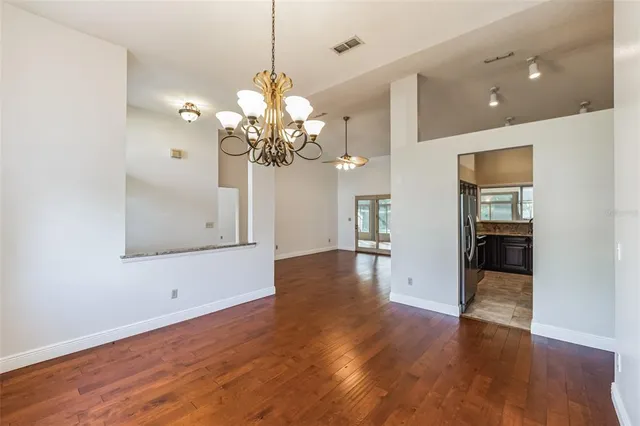 a view of a room with wooden floor and chandelier