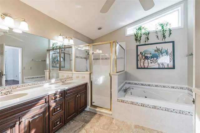 a bathroom with a granite countertop tub sink and mirror