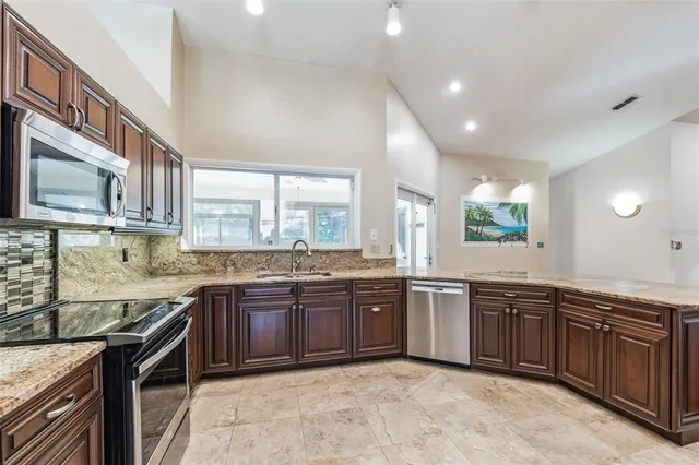 a kitchen with lots of wooden cabinets a sink and appliances