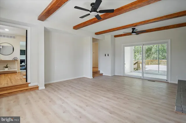 a view of empty room with wooden floor and fireplace