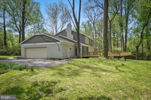 a view of a yard in front of a house with large trees