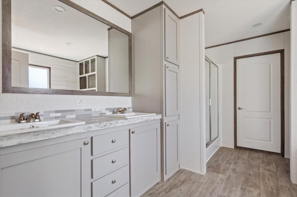 201 North Carpenter Street Mart, TX 76664 - Photo 12 of 30 a bathroom with a granite countertop sink and a mirror