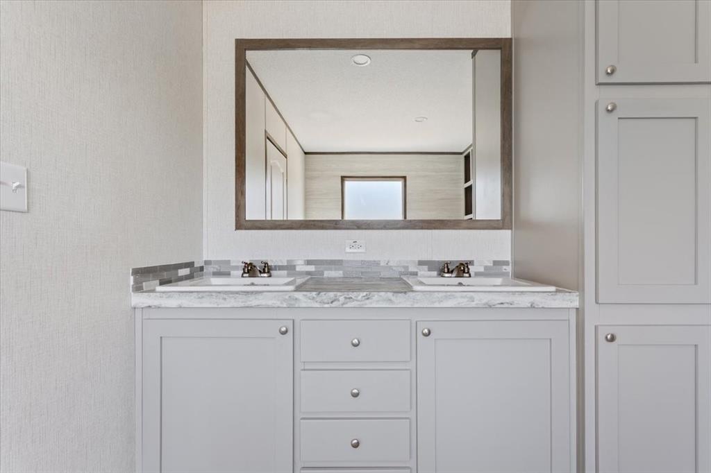 201 North Carpenter Street Mart, TX 76664 - Photo 13 of 30 a bathroom with a granite countertop sink vanity and mirror